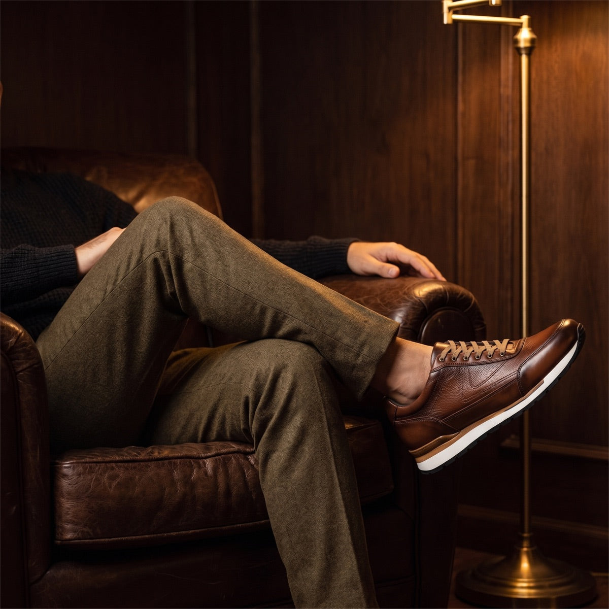 Hombre sentado en sillón de piel con tenis Toronto shedrón